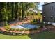 Beautiful backyard featuring a stone fire pit, a retaining wall of large rocks, and a variety of landscaped greenery at 2328 Mason Drive Dr, Atlanta, GA 30316