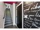 Hallway with staircase, decorative writing wall, black door, and gray-painted steps at 2328 Mason Drive Dr, Atlanta, GA 30316