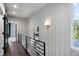 Upstairs hallway with an iron railing, shiplap accent wall and natural light from the window at 2328 Mason Drive Dr, Atlanta, GA 30316