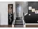Stylish staircase leading to upper levels with a black accent wall and pantry door at 2328 Mason Drive Dr, Atlanta, GA 30316