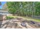 Spacious backyard with lush greenery, mature trees, and a stone patio with a fire pit at 3664 Bonnie Glenn Ln, Tucker, GA 30084