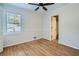 Bright bedroom with hardwood floors, a ceiling fan, and a window offering natural light at 3664 Bonnie Glenn Ln, Tucker, GA 30084