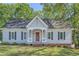 Charming single-story home with gray siding, black shutters, a red door and a well-manicured front lawn at 3664 Bonnie Glenn Ln, Tucker, GA 30084