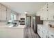 Bright kitchen with stainless steel appliances, white cabinets, countertops, and backsplash with views to the backyard at 3664 Bonnie Glenn Ln, Tucker, GA 30084