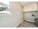 Functional laundry room with overhead cabinets, a window, and modern washer-dryer hookups at 3664 Bonnie Glenn Ln, Tucker, GA 30084