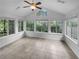 Bright sunroom featuring tile floors, ceiling fan, and multiple windows offering scenic outdoor views at 409 Kenley Ct, Mcdonough, GA 30253