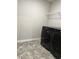 Laundry room with tile floor and modern black washer and dryer at 6615 Bluffview Dr, Douglasville, GA 30134