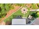 Aerial view of backyard featuring a fire pit, patio with grill, and meticulously landscaped lawn at 7430 Polo Hl, Cumming, GA 30040