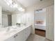 Bright bathroom featuring a double vanity and direct access to the bedroom at 7430 Polo Hl, Cumming, GA 30040