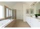 Bright bathroom featuring a soaking tub under large windows and a glass shower enclosure at 7430 Polo Hl, Cumming, GA 30040