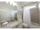 Bright bathroom with a tiled shower-tub combo, granite countertop, and gold hardware at 7430 Polo Hl, Cumming, GA 30040