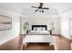 Serene bedroom with a king-size bed, tray ceiling, hardwood floors, and natural light from two windows at 7430 Polo Hl, Cumming, GA 30040