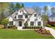 Stunning white brick home with a well-manicured lawn and mature trees offering curb appeal at 7430 Polo Hl, Cumming, GA 30040