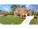 Beautiful brick home with a manicured lawn, mature trees, and a well-maintained landscape at 7430 Polo Hl, Cumming, GA 30040
