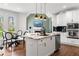 Spacious white kitchen featuring a large island with granite countertops, stainless appliances, and adjacent dining area at 7430 Polo Hl, Cumming, GA 30040