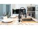 Close-up of a modern kitchen featuring stainless steel appliances, black backsplash and granite countertops at 7430 Polo Hl, Cumming, GA 30040