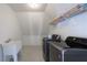 Well-lit laundry room with modern washer and dryer, and shelving for storage at 7430 Polo Hl, Cumming, GA 30040