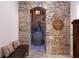 Rustic wine cellar featuring stone walls, brick flooring, and a wine barrel at 7430 Polo Hl, Cumming, GA 30040