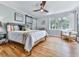 Bright bedroom with hardwood floors, a ceiling fan, and large windows overlooking greenery at 120 Huntcliff Pt, Atlanta, GA 30350