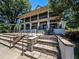 The community clubhouse has a multi-story facade with outdoor seating, columns, and staircases at 120 Huntcliff Pt, Atlanta, GA 30350