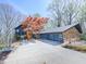Exterior view showcases the architectural design with stone and siding, an attached garage, and a well-maintained driveway at 120 Huntcliff Pt, Atlanta, GA 30350