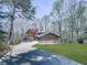 Exterior showcases stone accents, a lush lawn, and a long driveway leading to the property, surrounded by mature trees at 120 Huntcliff Pt, Atlanta, GA 30350