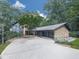 An exterior view of a house that features a stone facade and an attached garage surrounded by lush green trees at 120 Huntcliff Pt, Atlanta, GA 30350