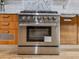 Close-up of stainless steel range and oven with custom wood cabinetry at 120 Huntcliff Pt, Atlanta, GA 30350