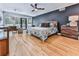 Spacious main bedroom featuring a private deck, hardwood floors, and dark accent wall at 120 Huntcliff Pt, Atlanta, GA 30350