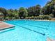 A community pool has clear blue water and is surrounded by lawn chairs and lifeguard stands at 120 Huntcliff Pt, Atlanta, GA 30350
