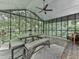 Enclosed sunroom with large windows, dining set, and view of the surrounding trees at 120 Huntcliff Pt, Atlanta, GA 30350