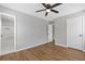 This bedroom offers wood floors, neutral walls, a ceiling fan, and two points of access to other rooms at 1379 Vintage Pointe Dr, Lawrenceville, GA 30044