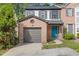 Charming two-story townhouse with a brick facade, attached garage, and a vibrant turquoise front door at 1379 Vintage Pointe Dr, Lawrenceville, GA 30044