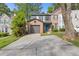 A home's garage and driveway with lawn, tree coverage, and a pop of blue at 1379 Vintage Pointe Dr, Lawrenceville, GA 30044