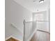 Bright upstairs hallway with hardwood floors, white banister, and natural light from the window at 1379 Vintage Pointe Dr, Lawrenceville, GA 30044