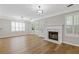 Open-concept living room with hardwood floors, fireplace, and lots of natural light from windows at 1379 Vintage Pointe Dr, Lawrenceville, GA 30044