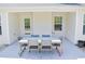 Covered patio with dining table and six chairs provides outdoor living space, with view to the yard at 3851 Bogan Mill Rd, Buford, GA 30519