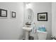 Elegant powder room featuring a pedestal sink, oval mirror, and stylish decor at 531 S Fortune Way, Dallas, GA 30157
