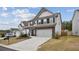 Two-story home with white siding, stone accents, a two-car garage, and a well-manicured lawn at 531 S Fortune Way, Dallas, GA 30157