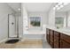 Bright bathroom featuring a shower, bathtub, double sink vanity, and window at 6270 Shiloh Woods Dr, Cumming, GA 30040