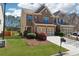 Well-maintained lawn leading to the brick front of this townhome with a two-car garage at 6270 Shiloh Woods Dr, Cumming, GA 30040