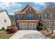 Brick front townhome with a two-car garage and blooming landscaping at 6270 Shiloh Woods Dr, Cumming, GA 30040
