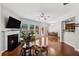 Comfortable living room with hardwood flooring, fireplace, and dining area in the background at 6270 Shiloh Woods Dr, Cumming, GA 30040