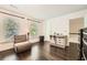 Bright bedroom featuring hardwood floors, two windows, comfortable seating, and stylish white trim at 7155 Roswell Rd # 15, Atlanta, GA 30328