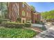 Brick townhome with manicured landscaping, featuring a charming entrance and attached garage at 7155 Roswell Rd # 15, Atlanta, GA 30328