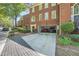 Brick townhome with a two-car garage and well-maintained landscaping at 7155 Roswell Rd # 15, Atlanta, GA 30328