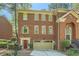 Charming brick townhome featuring an attached garage and a well-maintained front yard at 7155 Roswell Rd # 15, Atlanta, GA 30328