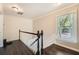 Upstairs hallway with dark wood floors, traditional railing and a light-filled window at 7155 Roswell Rd # 15, Atlanta, GA 30328