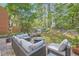 A brick patio with outdoor furniture and a lovely view of the wooded backyard at 7155 Roswell Rd # 15, Atlanta, GA 30328