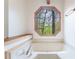 Relaxing bathtub with a view from the octagon-shaped window and a convenient bench seat at 1150 Autumn Ridge Dr, Marietta, GA 30066
